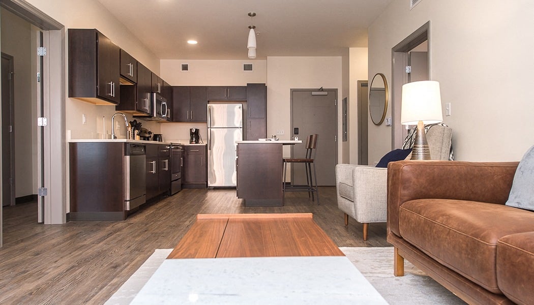 a living room and kitchen with a couch and a table